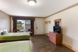 a bedroom with a bed and a flat screen tv at Malone Inn in Malone