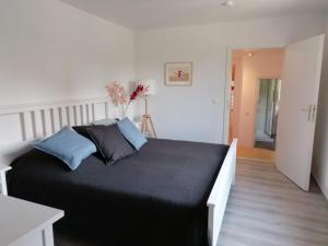 a bedroom with a large black bed with blue pillows at Townhouse Altstadt Wismar Upper Apartment mit zwei Terrassen in Wismar
