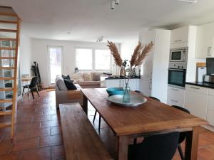 a kitchen and living room with a wooden table at Townhouse Altstadt Wismar Upper Apartment mit zwei Terrassen in Wismar