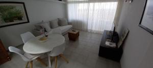 ein Wohnzimmer mit einem weißen Sofa, einem Tisch und Stühlen in der Unterkunft APARTAMENTO EN EL MEDANO - ESTRELLA DEL MAR in Granadilla de Abona