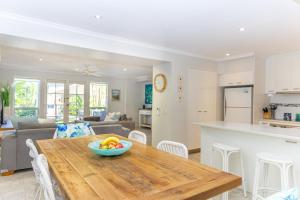 a kitchen and living room with a wooden table with a bowl of fruit at Sandy Beach Resort in Noosaville