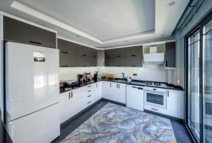 a kitchen with white cabinets and a large window at Villa Ada in Fethiye