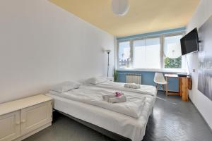 a bedroom with a large white bed and a desk at Wave Apartments - ŻUŁAWIANKA GDAŃSK in Gdańsk