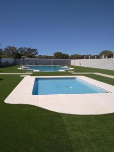 an image of a swimming pool on a lawn at La Cancela Apartamentos Turísticos in El Rocío