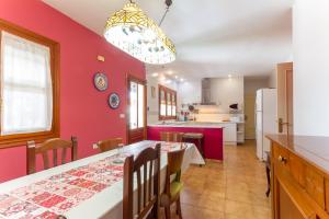 eine Küche und ein Esszimmer mit einer roten Wand in der Unterkunft Casa Rural Las Olivitas Alquiler completo in La Puebla de Almoradiel