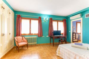 1 dormitorio con paredes azules, escritorio y silla en Casa Rural Las Olivitas Alquiler completo, en La Puebla de Almoradiel