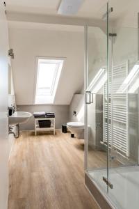 a bathroom with a glass shower and a sink at Suite Appartements Da Giovanni in Gladenbach