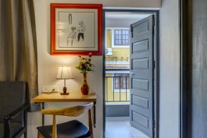 uma porta que dá acesso a um quarto com uma secretária e uma mesa em Hotel Plaza Inn by Rio em Calangute