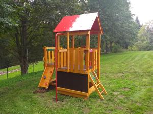 a playground with a slide in a field at Penzion Na Výsluní in Strašín