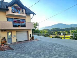 a house with a garage and a driveway at GARTNAR HOME -Hiška s pridihom domačnosti in pogledom na hribe. in Radovljica