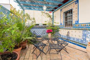 un patio con sillas y una mesa con plantas en CASA17 Santacruz Suites, en Sevilla