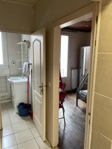 Cette chambre comprend une salle de bains pourvue d'un lavabo et d'une porte. dans l'établissement RENT APPART - Colombes, à Colombes