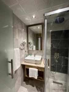 a bathroom with a sink and a shower at Nashira City Resort Hotel in Antalya