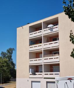 apartamentowiec z białymi balkonami i niebieskim niebem w obiekcie Bel appartement 2 chambres ,résidence privée w mieście Givet
