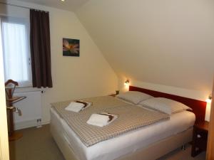 1 dormitorio con 1 cama con 2 toallas en Appartements im Hollandhaus, en Kurort Oberwiesenthal