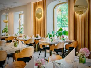 un restaurante con mesas y sillas blancas y una ventana en Jess Hotel & Spa Warsaw Old Town, en Varsovia