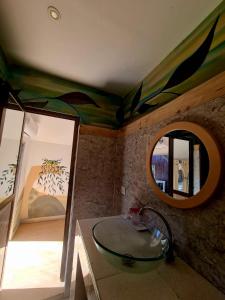 a bathroom with a glass sink and a mirror at Kinazi Upepo Beach Hotel in Paje