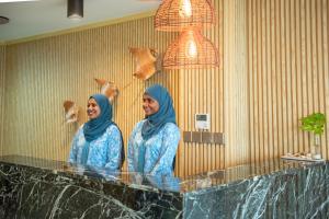 two women standing at a counter in a bathroom at Clarks Exotica, Kamadhoo Maldives in Baa Atoll