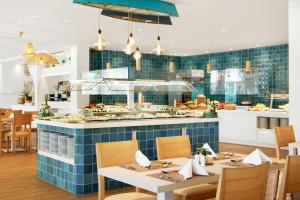 ein Restaurant mit einem Tisch und einer Theke mit Speisen in der Unterkunft Iberostar Club Cala Barca All Inclusive in Portopetro