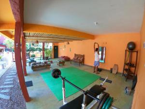 a woman standing in a living room with a gym at Pousada Beleza Pura na Praia da Ferrugem in Garopaba