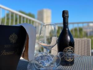 una botella de vino sentada en una mesa con una copa en Gli Angeli - Affittacamere, en Monte SantʼAngelo