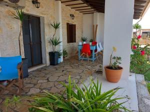 Nikotsaras beach house since 1930 في أكارافي: فناء مع طاولة وكراسي والنباتات