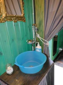 a bathroom with a blue tub on a wooden counter at Yogaville Sardegna in Luras