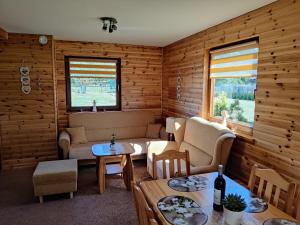 uma sala de estar com um sofá e uma mesa em Domek z Klimatem em Smoldziński Las
