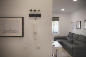 ein Wohnzimmer mit einem Sofa und einem Telefon an der Wand in der Unterkunft Acogedor apartamento en Triana in Sevilla
