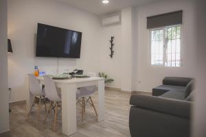 ein Wohnzimmer mit Tisch und Couch in der Unterkunft Acogedor apartamento en Triana in Sevilla