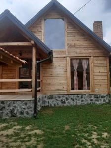 a log cabin with a porch and a window at Vikendica Jovicic in Kraljevo
