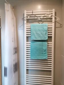 a towel rack with four blue towels in a bathroom at Apartment GINA in Innsbruck