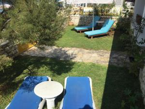 un grupo de sillas y mesas azules en un patio en Nikotsaras beach house since 1930 en Acharavi