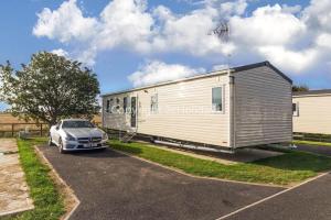 a silver car parked in front of a trailer at 6 Berth Caravan For Hire At Seawick Holiday Park By The Beach Ref 27011hv in Clacton-on-Sea