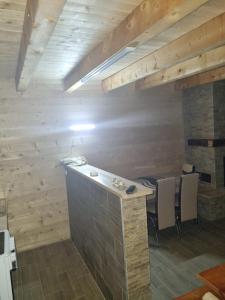 a bar in a room with a stone fireplace at Vikendica Jovicic in Kraljevo +3 photos