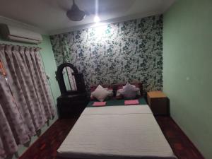 a bedroom with two beds and a mirror at AnNur Homestay in Lahad Datu