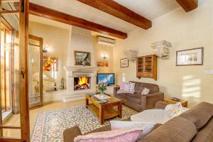 a living room with a couch and a fireplace at Djar ta Menzja 2 Holiday Home in Sannat