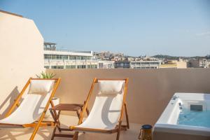 two chairs and a hot tub on a balcony at The Suite Athens in Athens