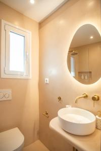 a bathroom with a sink and a mirror at The Suite Athens in Athens