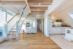 a staircase in a house with white walls and wooden ceilings at Appartement Friesenloft in Tinnum