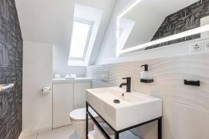 a white bathroom with a sink and a toilet at Appartement Friesenloft in Tinnum +21 photos