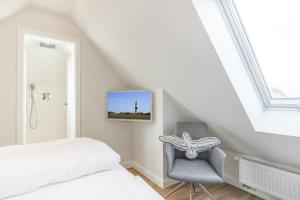 a bedroom with a bed and a chair at Appartement Friesenloft in Tinnum