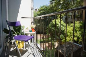 einen lila Stuhl auf einem Balkon mit einem Tisch in der Unterkunft 4gZg Apartment in Zagreb
