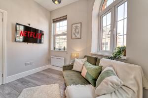 a living room with a couch and a tv at Guest Homes - Bennett Apartment in Worcester