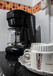 a coffee cup sitting on a counter next to a coffee maker at Sea Star Inn in San Andrés