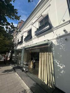ein Geschäft vor einem weißen Gebäude mit Fenster in der Unterkunft Cvetni trg in Belgrad