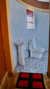 een badkamer met een toilet en een wastafel bij Sina Village in Mpigi