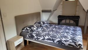 a bedroom with a bed with a blue and white comforter at Votre maison en Touraine in Chissay-en-Touraine