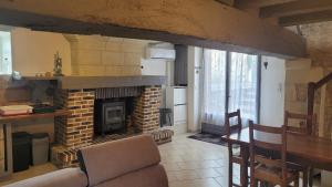 a living room with a brick fireplace and a table at Votre maison en Touraine in Chissay-en-Touraine
