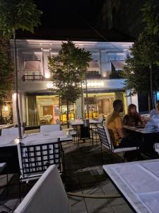 eine Gruppe von Menschen, die nachts in einem Restaurant im Freien sitzen in der Unterkunft Cvetni trg in Belgrad